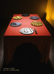table settign from head of table showing 6 animal skin patterned plates, and a hunting knife